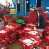 Thương lái mua cá của ngư dân tại cảng cá Thuận An. (Ảnh: Hồ Cầu/TTXVN)