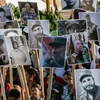 Người dân mang theo di ảnh của cố Lãnh tụ Fidel Castro tham gia lễ tuần hành tại Santiago de Cuba ngày 4/12. (Ảnh: THX/TTXVN)