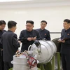 Nhà lãnh đạo Triều Tiên Kim Jong-un (thứ ba, phải) thị sát quy trình gắn đầu đạn hạt nhân thu nhỏ vào tên lửa Hwasong-14 tại Viện Khoa học hạt nhân. (Ảnh: Yonhap/TTXVN)