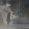 Một người đàn ông đứng gần nắp hầm gas vào một ngày lạnh ở Bắc Kinh, Trung Quốc, ngày 1/12 vừa qa. (Nguồn: Reuters)