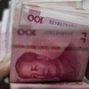 Kiểm tiền mệnh giá 100 nhân dân tệ ở Bắc Kinh. (Ảnh: AFP/TTXVN)