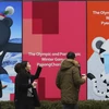 Mọi người đi qua áp phích quảng cáo các tượng linh vật Olympic mùa đông Pyeongchang 2018 tại Seoul, Hàn Quốc. (Nguồn: AP)