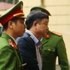 Cảnh sát dẫn giải bị cáo Đinh La Thăng vào phòng xét xử. (Ảnh: Doãn Tấn/TTXVN)
