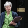 Thủ tướng Anh Theresa May rời khỏi tòa nhà Chính phủ để tới phiên họp Quốc hội ở London ngày 12/6 vừa qua. (Ảnh: AFP/TTXVN)