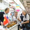 Các đối tác nước ngoài tìm hiểu các mặt hàng và cơ hội hợp tác kinh doanh với các doanh nghiệp Việt Nam tại Hội chợ. (Ảnh: Nguyễn Thanh/Vietnam+)
