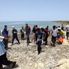 Người di cư tới bờ biển ở phía đông Tripoli của Libya sau khi được cứu trên biển ngày 29/6 vừa qua. (Ảnh: THX/TTXVN)