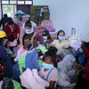 Đóng gói quần áo quyên góp tại trung tâm huyện Sanamsay để chuyển đến cho người dân vùng bị ảnh hưởng bởi sự cố vỡ đập. (Ảnh: Phạm Kiên/TTXVN)
