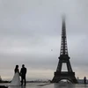  Một cặp đôi chụp ảnh cưới tại khu vực Tháp Eiffel ở Paris. (Ảnh: AFP/TTXVN)
