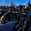 Cảnh sát Romania cố gắng ngăn chặn những người biểu tình quá khích tại Bucharest ngày 10/8. (Ảnh: AFP/TTXVN)