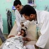 Nhân viên y tế điều trị cho một em nhỏ bị thương trong vụ không kích ở Saada. (Ảnh: AFP/TTXVN)