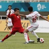 Pha tranh bóng giữa Quang Hải và cầu thủ Olympic UAE. (Ảnh Hoàng Linh/TTXVN) 