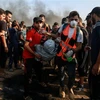 Nhân viên y tế Palestine chuyển người biểu tình bị thương trong xung đột với binh sỹ Israel tại khu vực biên giới Dải Gaza ngày 28/9. (Ảnh: THX/TTXVN)