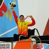Vận động viên Võ Thanh Tùng tự hào giơ cao tấm Huy chương vàng thứ 3 tại Asian Para Games 2018. (Ảnh: Hải Ngọc/TTXVN)