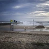 Người dân dỡ bỏ các tấm biển quảng cáo dọc bờ biển tại Costa da Caparica của Bồ Đào Nha trước bão Leslie ngày 13/10. (Ảnh: AFP/TTXVN)