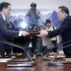 Bộ trưởng Thống nhất Hàn Quốc Cho Myoung-gyon (trái) và Chủ tịch Ủy ban Tái thống nhất hòa bình Ri Son-gwon (phải) trao đổi văn kiện sau hội đàm cấp cao liên Triều ở làng đình chiến Panmunjom ngày 15/10. (Ảnh: Yonhap/TTXVN)