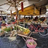 Người dân mua sắm tại một khu chợ ở Rome của Italy. (Ảnh: AFP/TTXVN)