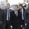 Tổng thống Pháp Emmanuel Macron (ở giữa) tới khu vực Khải Hoàn Môn ở thủ đô Paris để xem xét những thiệt hại do những đối tượng biểu tình quá khích gây ra. (Ảnh: AFP/TTXVN)