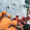 Nhân viên Trung tâm Phối hợp tìm kiếm, cứu nạn Hàng hải Khu vực 4 đưa nạn nhân bị thương từ tàu cứu nạn SAR 27-01 lên bờ. (Ảnh: Phan Sáu/TTXVN) 