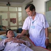 Bác sỹ Nguyễn Thanh Phong, Trưởng khoa Nhiễm D, Bệnh viện Bệnh Nhiệt đới Thành phố Hồ Chí Minh khám bệnh cho bệnh nhân mắc sốt xuất huyết. (Ảnh: Đinh Hằng/TTXVN)