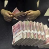 Kiểm tiền nhân dân tệ tại một ngân hàng của Trung Quốc. (Nguồn: Reuters)