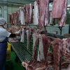 Phân loại thịt lợn đã chế biến và treo trên giá đảm bảo an toàn vệ sinh thực phẩm tại nhà máy. (Ảnh: Vũ Sinh/TTXVN)