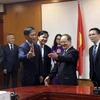Bộ trưởng Bộ Công thương Trần Tuấn Anh đón đồng chí Lộc Tâm Xã. (Ảnh: Trần Việt/TTXVN)