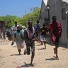 Người dân sơ tán khỏi hiện trường vụ tấn công ở Mogadishu của Somalia, ngày 23/3 vừa qua. (Ảnh: AFP/TTXVN)