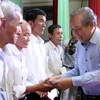 Phó Thủ tướng Thường trực Trương Hòa Bình trao quà cho các gia đình chính sách. (Ảnh: Trần Thị Thu Hiền/TTXVN)