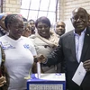 Tổng thống Nam Phi Cyril Ramaphosa (phải) đồng thời là Chủ tịch đảng Đại hội Dân tộc Phi (ANC) cầm quyền bỏ phiếu tổng tuyển cử tại điểm bầu cử ở Soweto ngày 8/5 vừa qua. (Ảnh: AFP/TTXVN)
