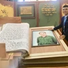 Kỷ lục gia, nghệ nhân thư pháp Võ Dương bên tác phẩm sách thư pháp về Đại tướng Võ Nguyên Giáp. (Ảnh: Võ Dung/TTXVN)