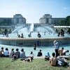 Người dân tránh nắng nóng bên vòi phun nước tại Paris của Pháp, ngày 26/6 vừa qua. (Ảnh: THX/TTXVN)