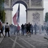 Cảnh sát phun hơi cay để giải tán đám đông người biểu tình quá khích tại đại lộ Champs Elysees ở thủ đô Paris, Pháp, ngày 14/7. (Ảnh: AFP/TTXVN)