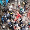 Lực lượng cứu hộ tìm kiếm nạn nhân bị mắc kẹt dưới đống đổ nát của tòa nhà bị sập ở Mumbai, Ấn Độ ngày 16/7. (Ảnh: India Today/TTXVN)