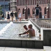 Người dân giải nhiệt tránh nóng tại một đài phun nước ở Berlin, Đức ngày 25/7. (Ảnh: THX/TTXVN)