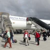 Hành khách xuống máy bay tại sân bay Cape Town của Nam Phi. (Ảnh: Phi Hùng/TTXVN)