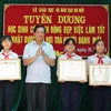 Phó Giám đốc Sở Giáo dục và Đào tạo Hà Nội Phạm Xuân Tiến trao Giấy khen của Giám đốc Sở cho 3 học sinh. (Ảnh: Thanh Tùng/TTXVN)
