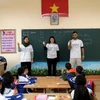 Các tình nguyện viên hướng dẫn các em học sinh trường Tiểu học và THCS Lê Văn Tám (thị trấn Sa Pa) học văn hóa bằng tiếng Anh. (Ảnh: Quốc Khánh/TTXVN)