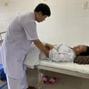 Bác sỹ thăm khám cho bệnh nhân Nguyễn Thị A sau khi phẫu thuật. (Ảnh: TTXVN phát)