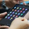 Khách hàng trải nghiệm điện thoại Samsung Galaxy Fold tại một cửa hàng ở Seoul, Hàn Quốc ngày 6/9 vừa qua. (Ảnh: Yonhap/TTXVN)