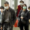 Người dân đeo khẩu trang để ngăn ngừa lây nhiễm. (Ảnh: AFP/TTXVN)