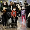Hành khách đeo khẩu trang để phòng tránh sự lây lan của virus corona tại sân bay Bắc Kinh, Trung Quốc, ngày 21/1. (Ảnh: AFP/TTXVN)