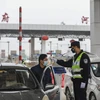 Kiểm tra thân nhiệt của lái xe trên tuyến đường cao tốc ở Vũ Hán, tỉnh Hồ Bắc, Trung Quốc, ngày 24/1. (Ảnh: AFP/TTXVN)