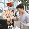 Cảnh sát giao thông Hà Nội sử dụng phương tiện an toàn kiểm tra nồng độ cồn trong khí thở đối với người tham gia giao thông. (Ảnh: Doãn Tấn/TTXVN)