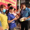 Phát khẩu trang cho công nhân tại ở tỉnh Bình Phước. (Ảnh: Dương Chí Tưởng/TTXVN)