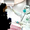 Kiểm tra thân nhiệt phòng lây nhiễm COVID-19 tại sân bay quốc tế ở Bắc Kinh, Trung Quốc, ngày 7/3. (Ảnh: THX/TTXVN)