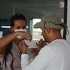 Hành khách nước ngoài đeo khẩu trang sau khi được các nhân viên tại Ga Đà Nẵng nhắc nhở. (Ảnh: Văn Dũng/TTXVN)