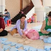 Các thành viên trong gia đình bà Nguyễn Thị Cội, ở thị trấn Tầm Vu, huyện Châu Thành cùng chị em phụ nữ chung sức cắt, may khẩu trang tặng người dân phòng dịch. (Ảnh: Đức Hạnh/TTXVN)
