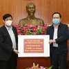 Chủ tịch Ủy ban Trung ương MTTQ Việt Nam Trần Thanh Mẫn trao tượng trưng kinh phí cho đại diện Bộ Y tế. (Ảnh: Doãn Tấn/TTXVN)