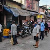 Người dân xếp hàng lấy sữa tại khu ổ chuột Dharavi ở Mumbai, Ấn Độ, ngày 6/4 vừa qua. (Ảnh: AFP/TTXVN)