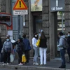 Người dân đợi xe buýt tại bến xe ở Milan, Italy ngày 18/4/2020 trong bối cảnh dịch COVID-19 đang hoành hành. Ảnh: THX/TTXVN